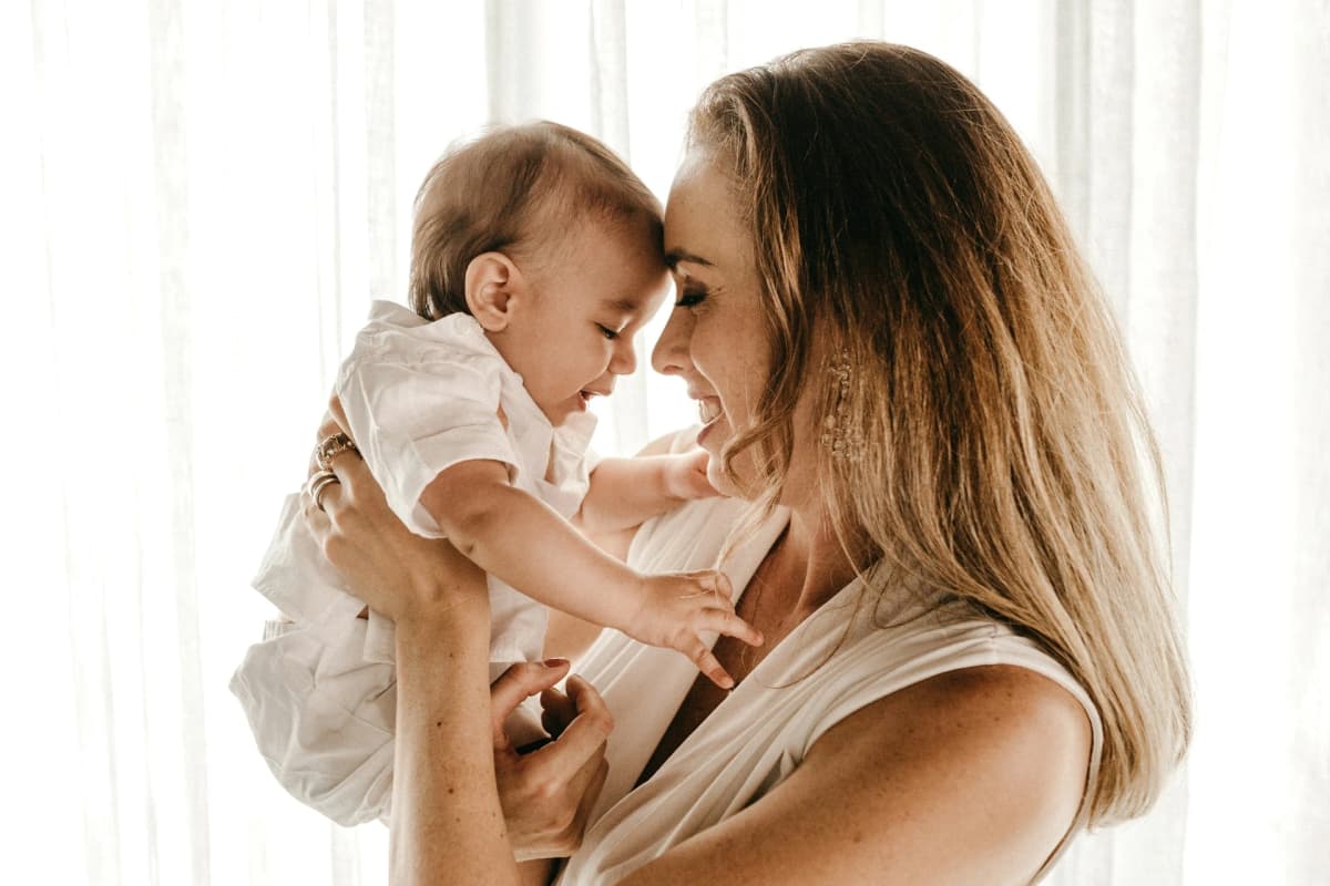 Smiling doula holding a newborn baby close